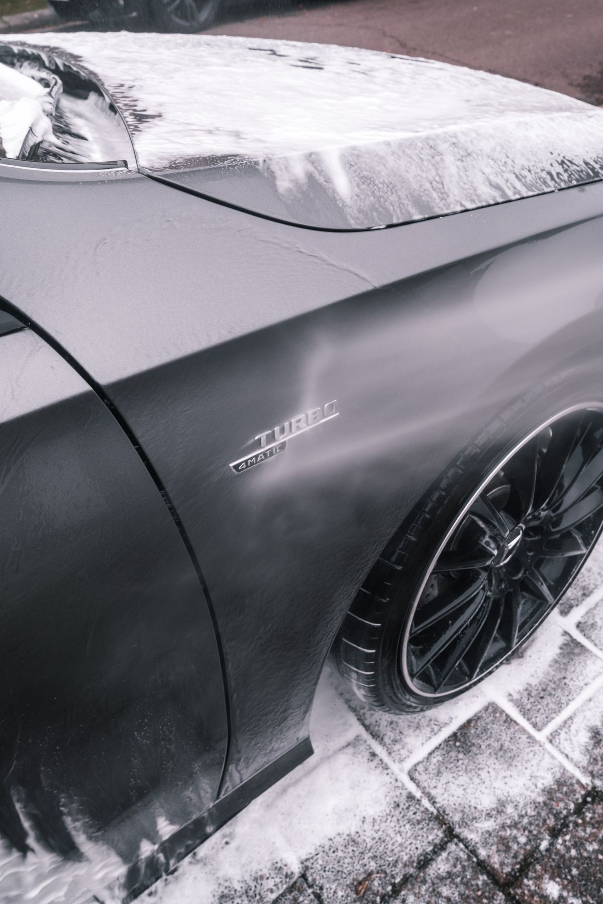 Foam on the bonnet and wheel of a dark car
